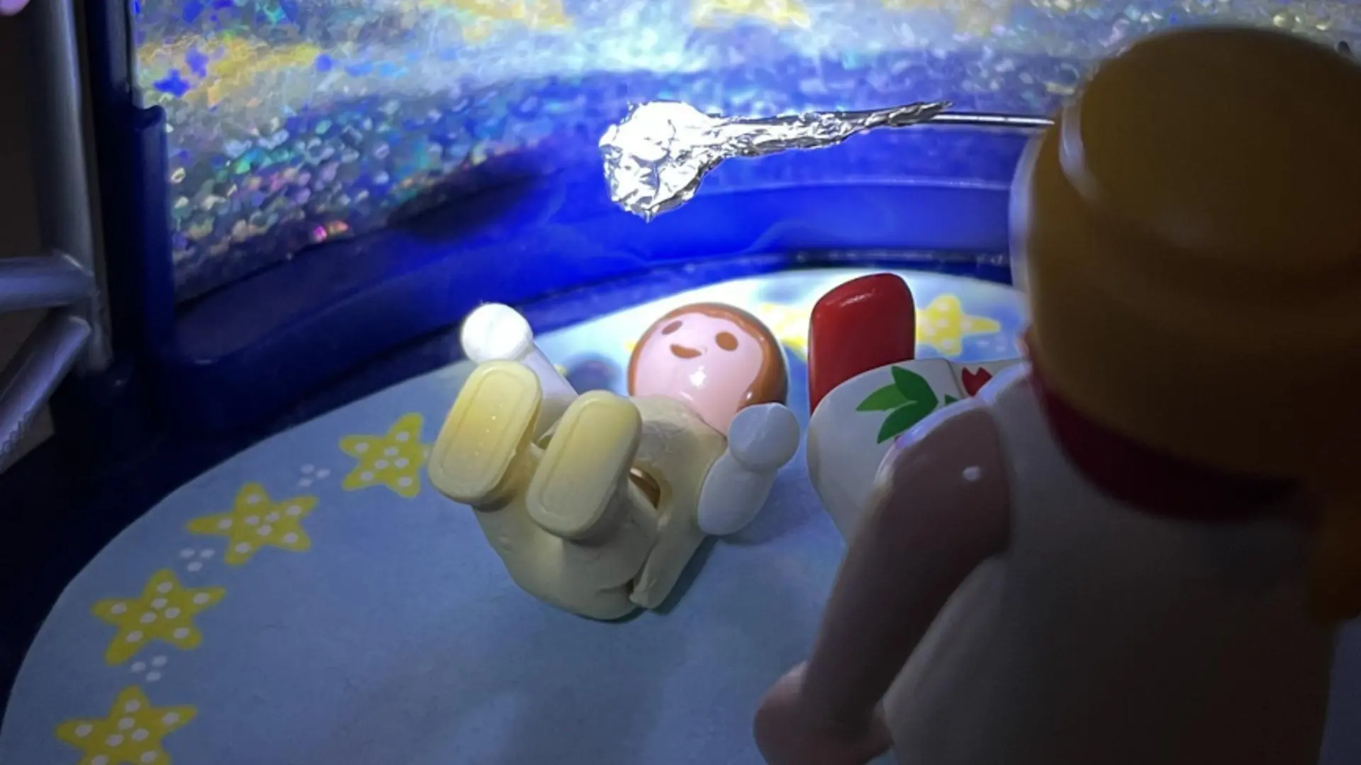 Zwei Playmobil-Figuren, ein Erwachsener und ein Baby, stellen Sehtraining der Frühförderung nach