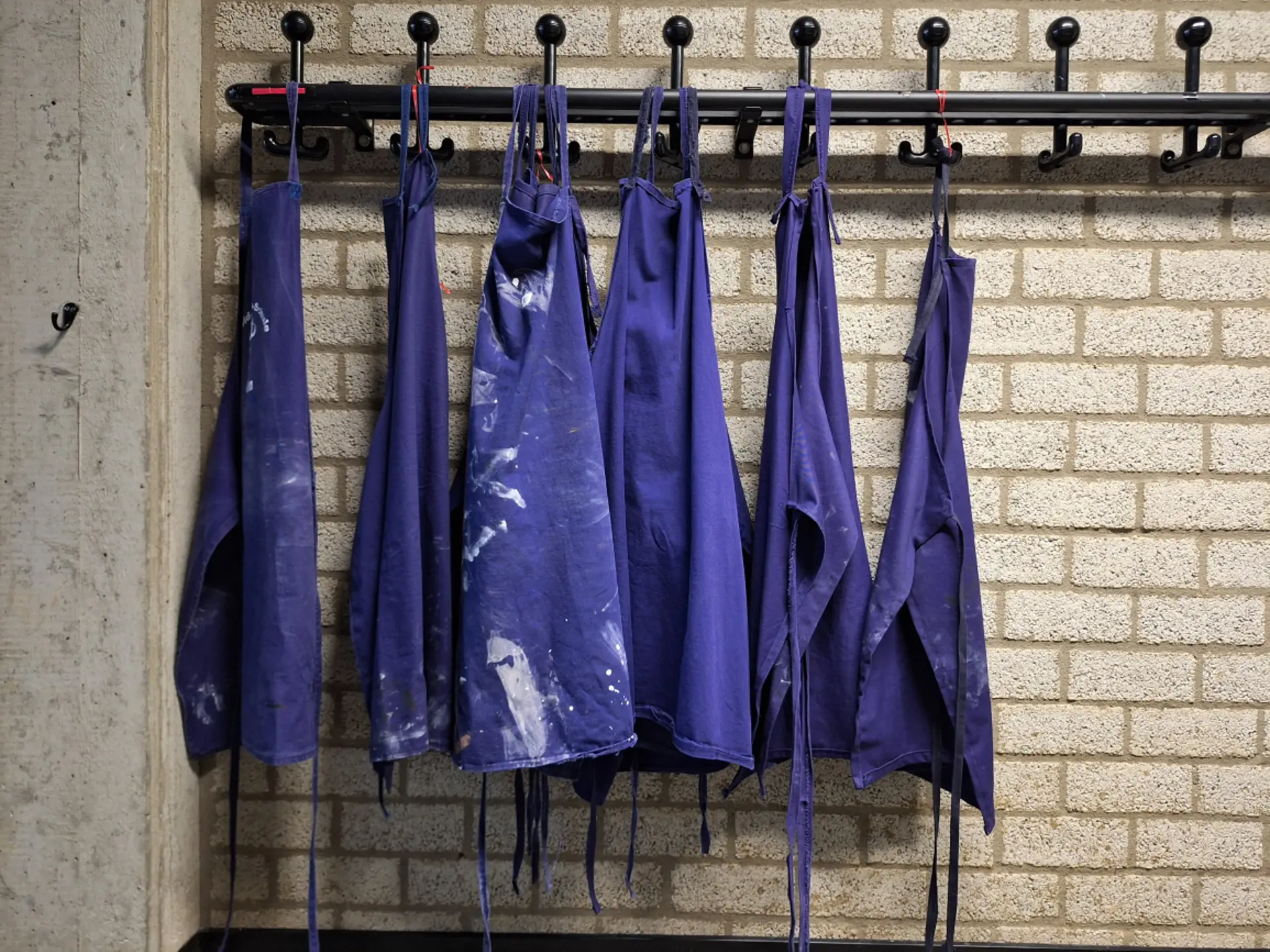 Kittel hängen an Haken im Werkraum