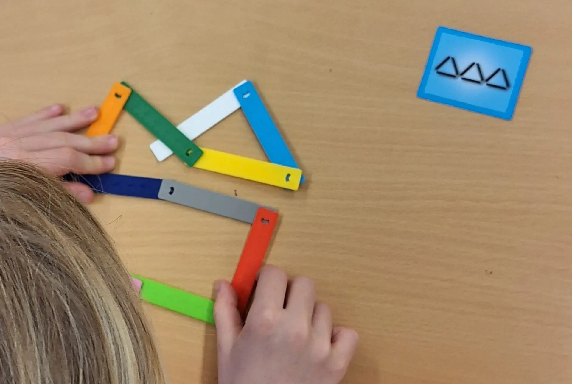 Kind macht im Gemeinsamen Lernen visuelle Wahrnehmungsförderung mit Figurenformer