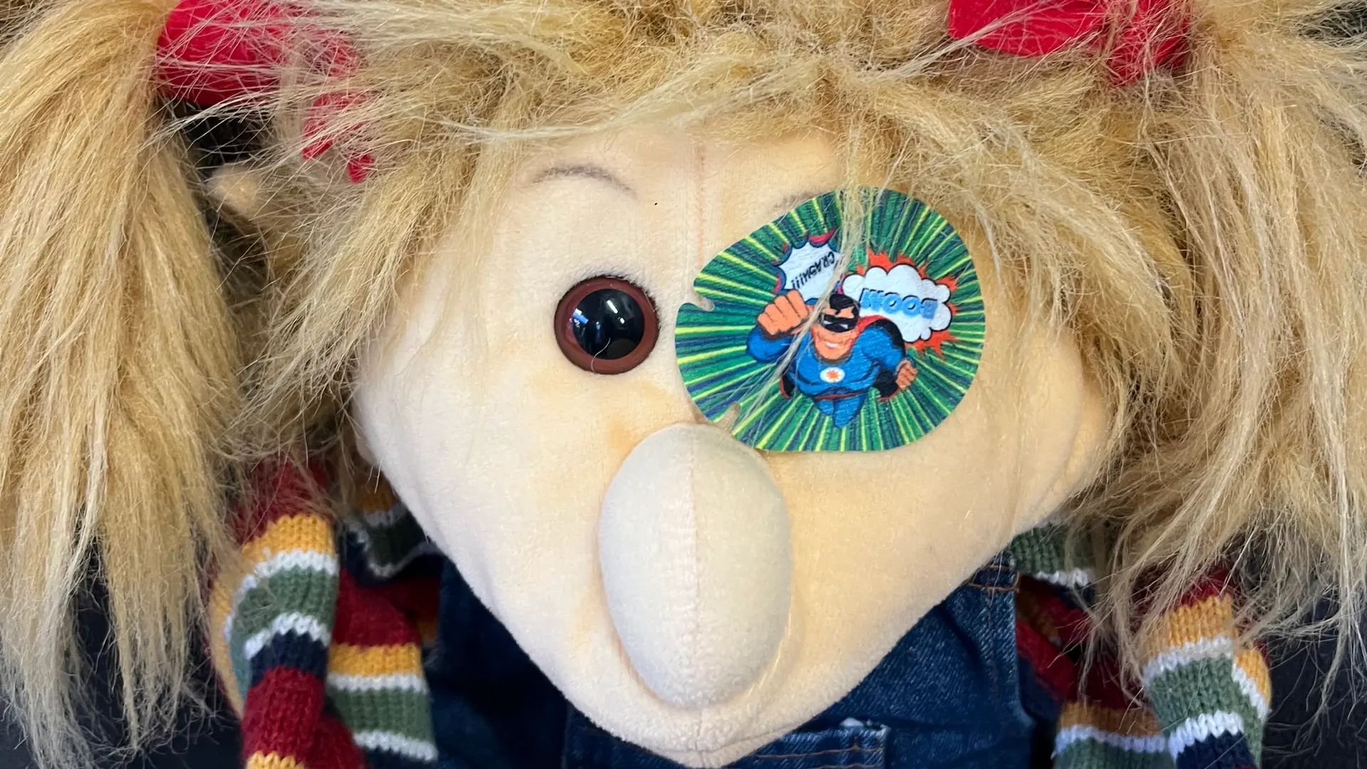 Handpuppe mit einem Okklusionspflaster auf dem linken Auge.