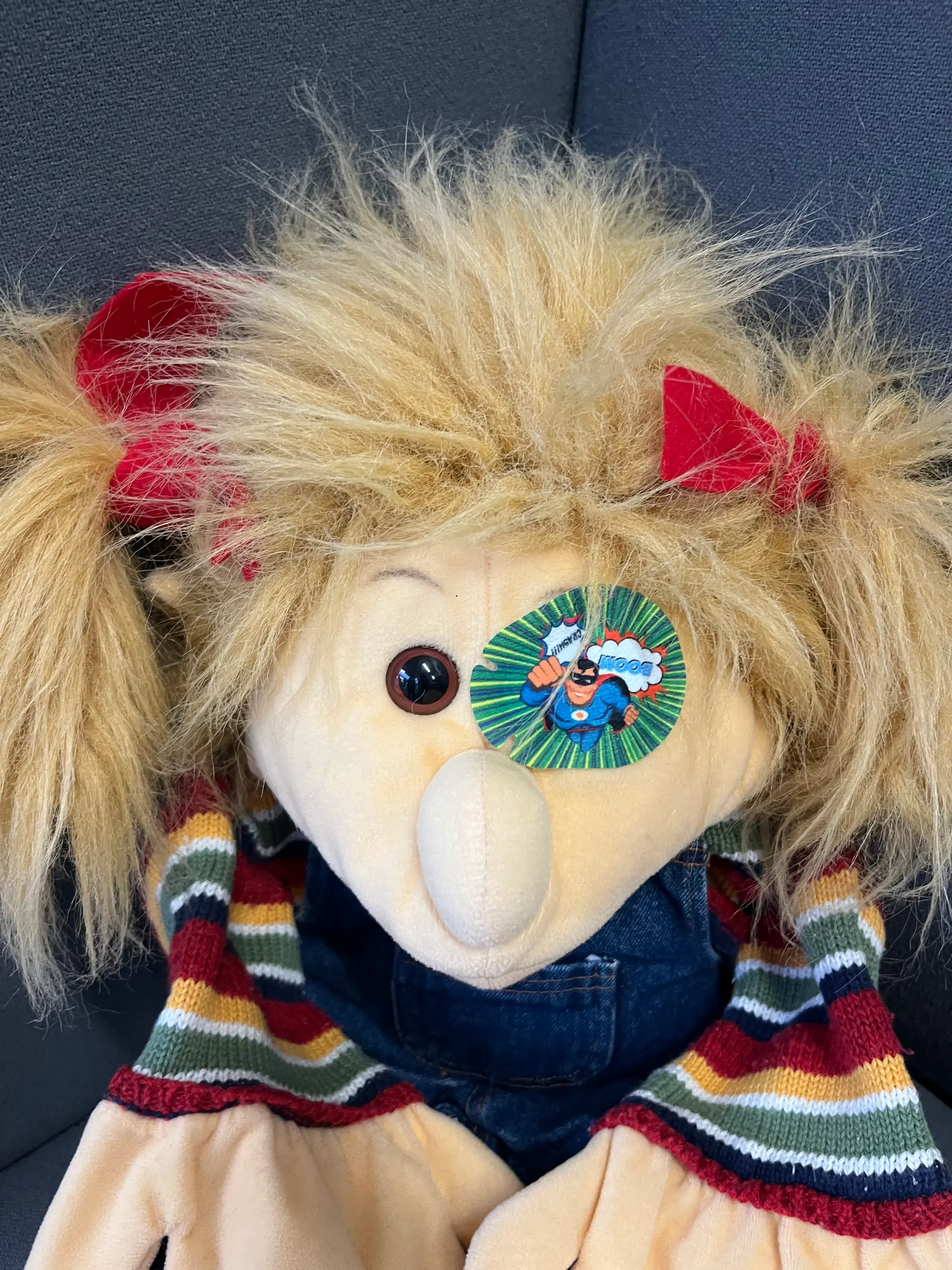 Handpuppe mit einem Okklusionspflaster auf dem linken Auge.