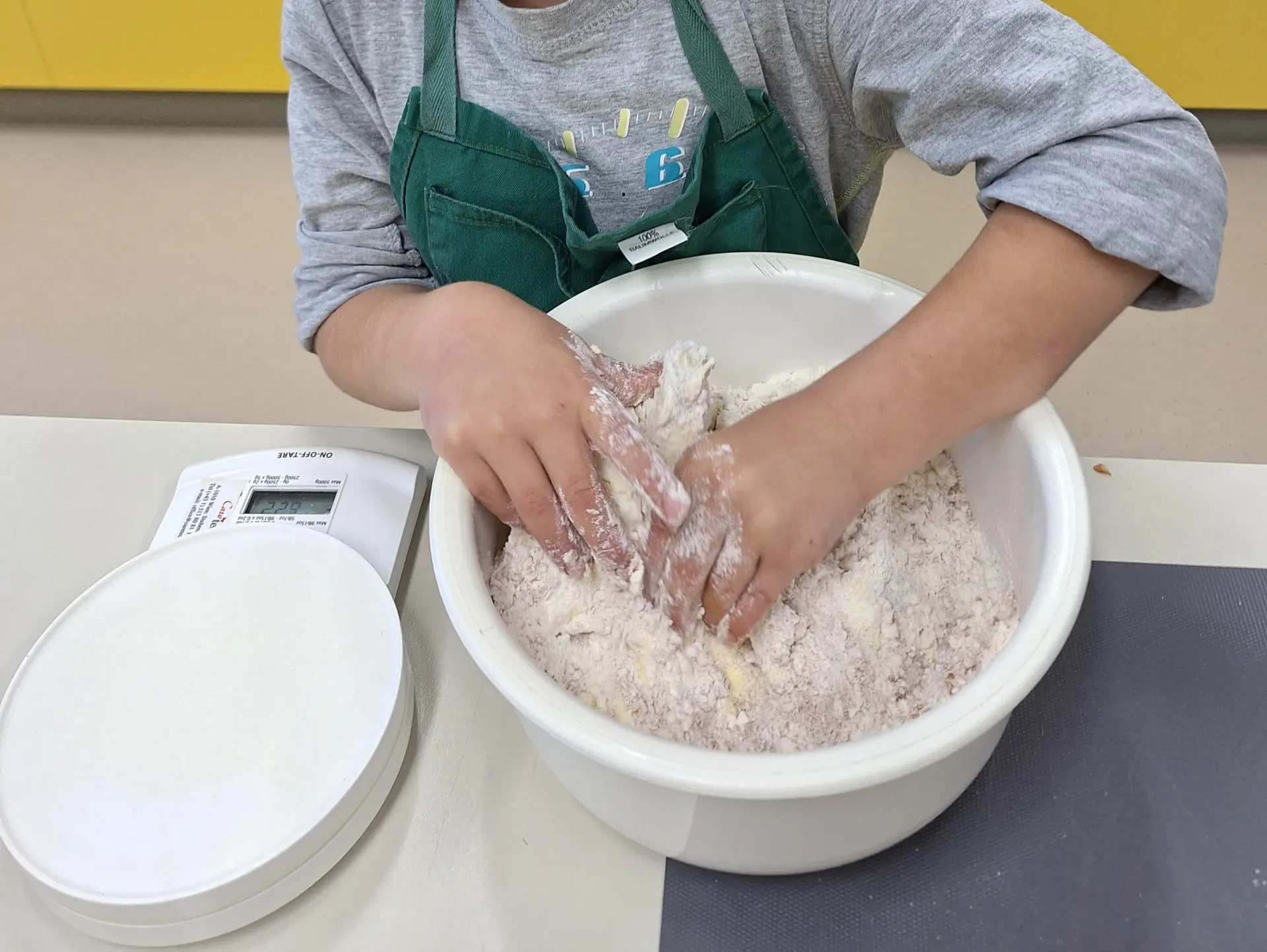 Kind knetet Teig für Apfelkuchen