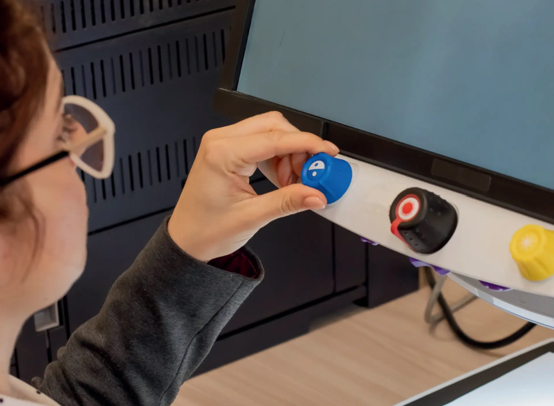 Kind mit Sehbeeinträchtigung stellt seinen Bildschirm ein