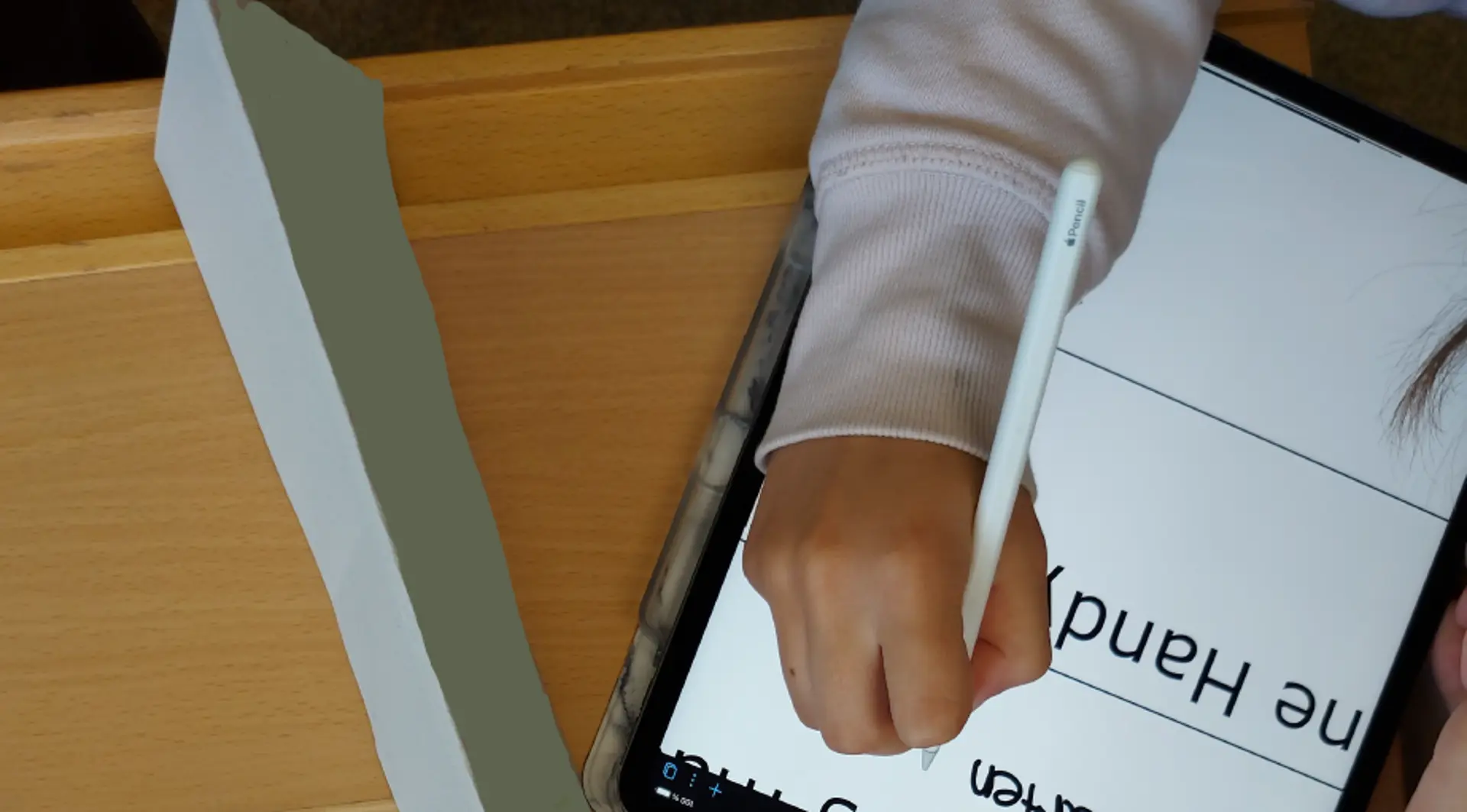 Kind schreibt auf Tablet mit digitaler Vergrößerung